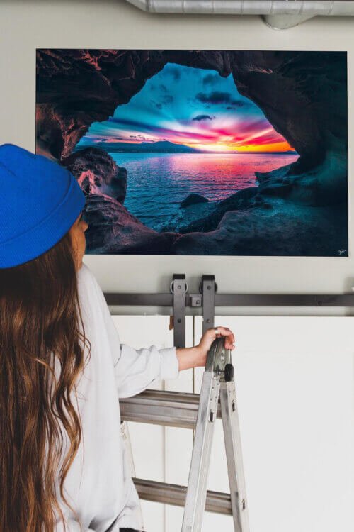 Landscape photography wall art of sunset as viewed through a hole in a rock