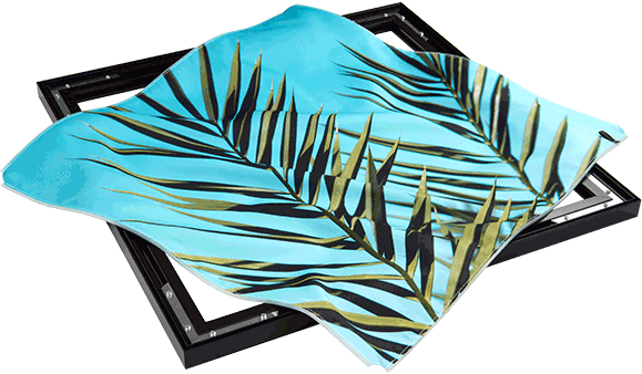 Before and after of custom BIG Wall Decor print being inserted into a black metal frame. Both prints show the same photo of palm leaves with a bright blue background. On the left, the print is draped over the frame. On the right, the print is inserted in the frame. It is stretched smooth and taut, like a canvas.