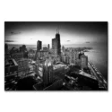 Aerial view of Chicago's downtown loop in black and white, showcasing the skyline and iconic buildings against a twilight sky.