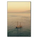 A sailboat on calm waters during a sunset in Italy.
