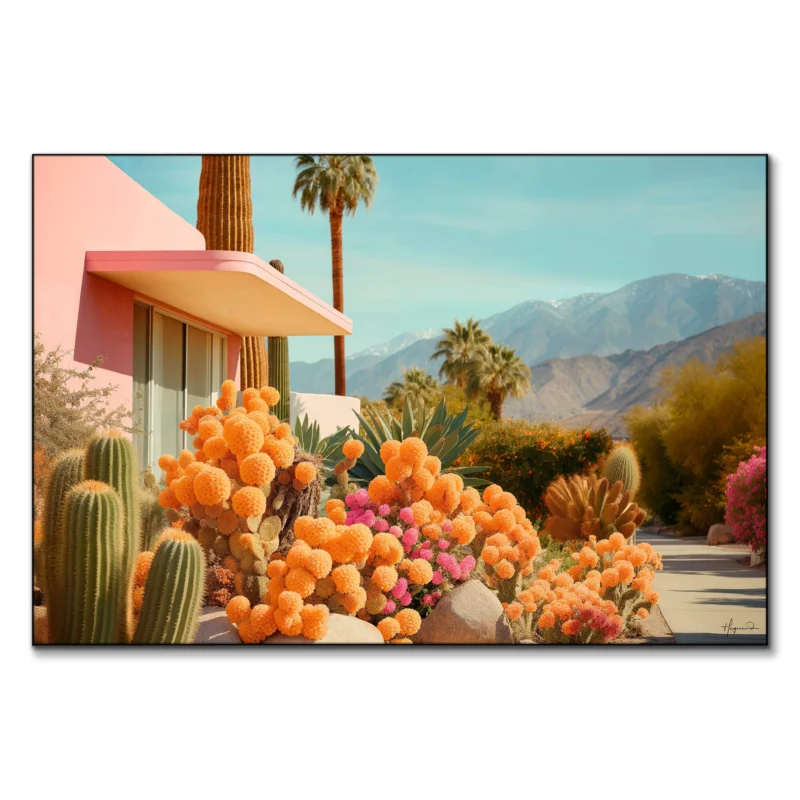 Modern house with pink facade surrounded by vibrant orange and pink cacti, tall palm trees, and mountains under a clear blue sky.