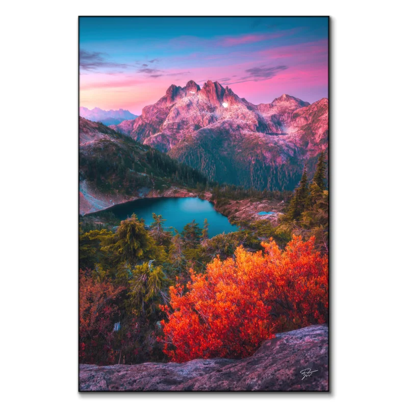 Scene in the North Cascades, Washington, featuring rugged peaks, an alpine lake, and vibrant autumn foliage under a pink twilight sky.