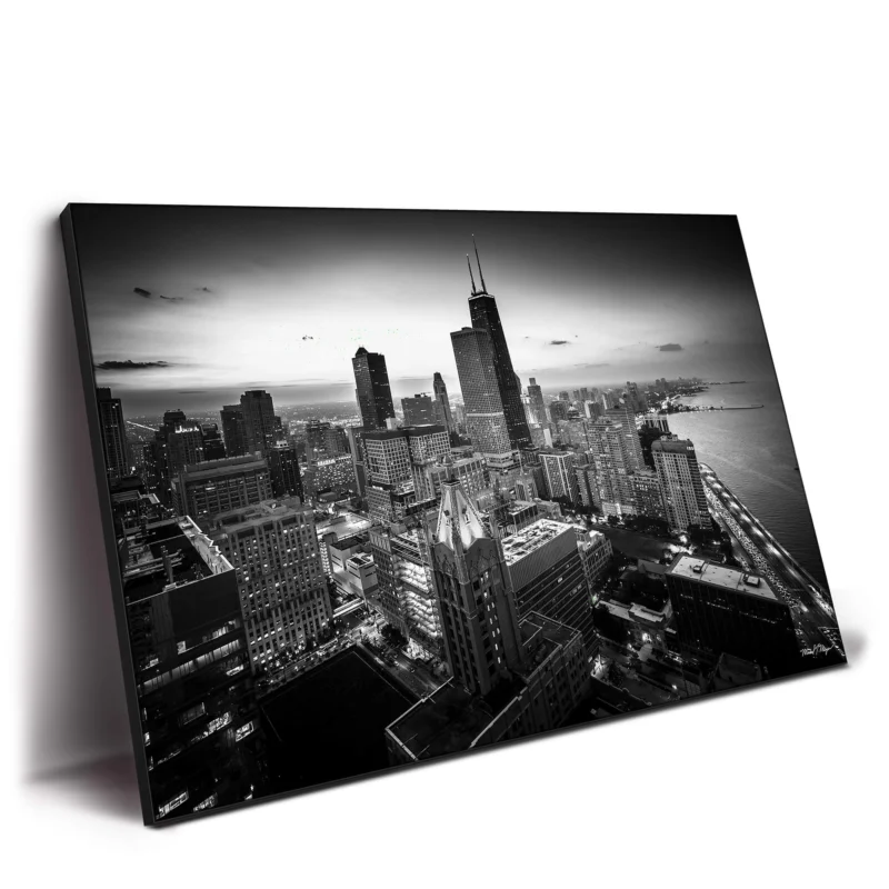 Aerial view of Chicago's downtown loop in black and white, showcasing the skyline and iconic buildings against a twilight sky.