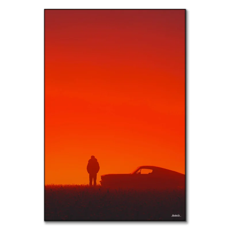 A silhouette of a man standing next to a vintage car against a red sunset backdrop.